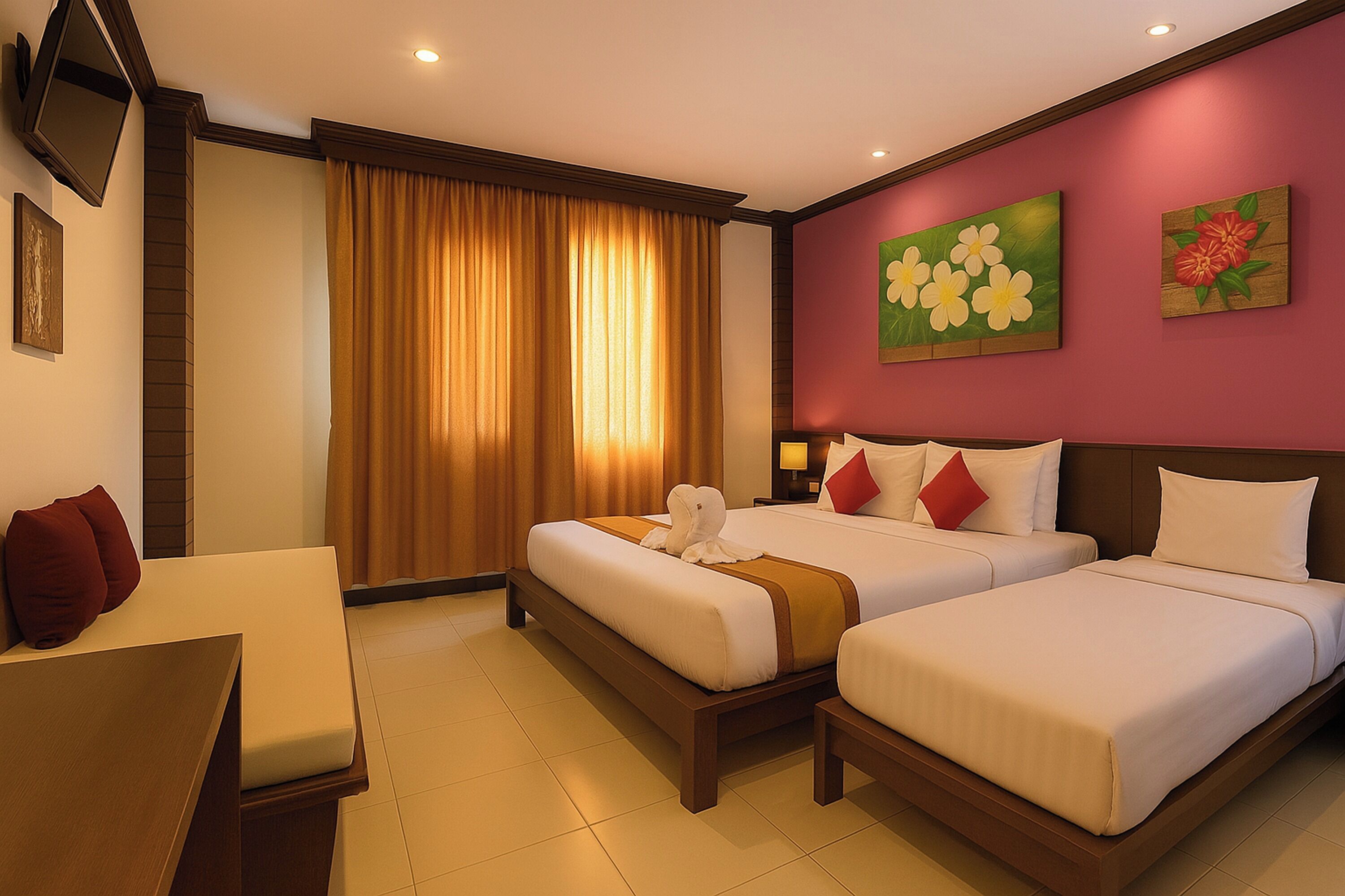 A hotel room with two beds, a desk, and a TV.