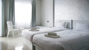 A modern hotel room with two beds, a chair, and a small table. - Aonang Miti Resort (Krabi)