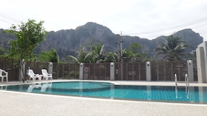 A swimming pool with a view of mountains, surrounded by a fence and palm trees. - Aonang Miti Resort (Krabi)