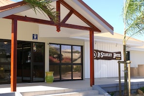 The exterior of Le Stanley Hotel with a covered entrance, large windows, and a signboard. - Le Stanley Hotel and Suites (Nouméa)