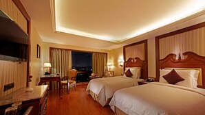 A hotel room with two beds, a desk, a chair, and a TV. - Hablis Hotel (Chennai)