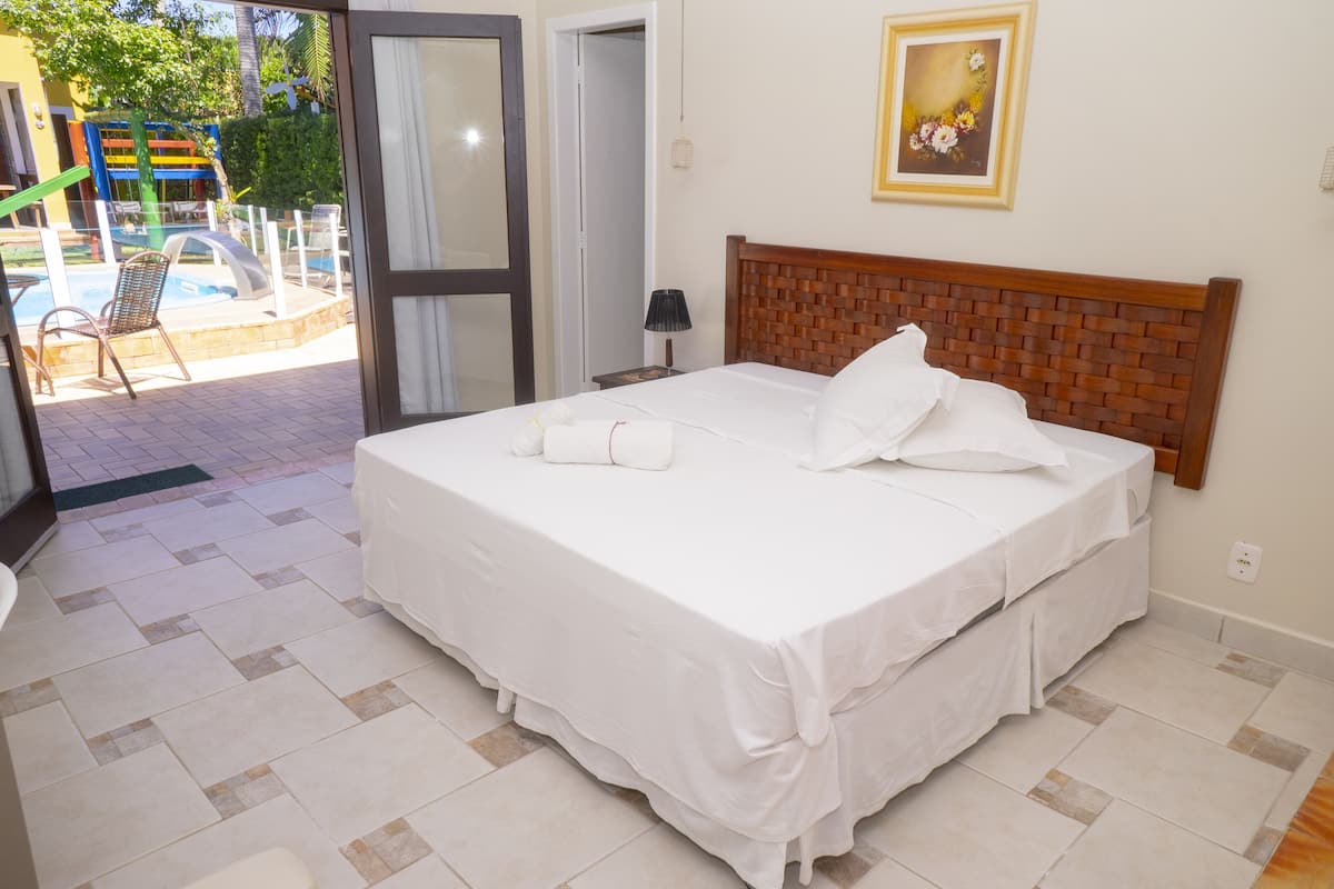 Ein Hotelzimmer mit Bett, Bad und Blick auf einen Außenpool.