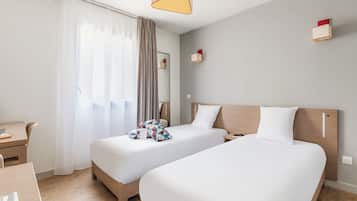 Una habitación de hotel con dos camas, un escritorio y una silla.