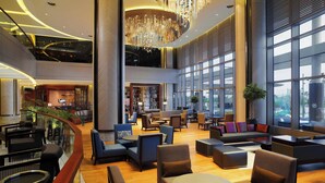A spacious lobby with seating areas, a reception desk, and large windows providing views. - Sheraton Grand Adana (Adana)
