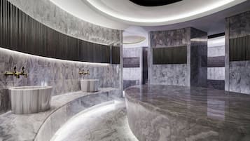 Bathroom features two sinks with faucets and a sleek, curved design.