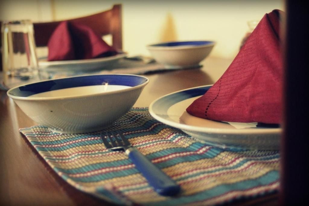 Een eettafel met een placemat, kommen, een vork en een servet.