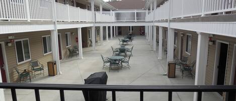 A courtyard with outdoor seating and a barbecue grill.