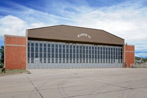 A large, single-story building with a flat roof and a sign reading "HANGAR 25" above the entrance. - Knights Inn Big Spring (Big Spring)
