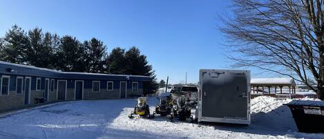 A building with multiple rooms, a covered outdoor area, and a snow-covered ground.