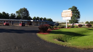 Un motel de Pine Ridge, avec une enseigne bien visible, un parking et un espace verdoyant agrémenté d’arbustes.