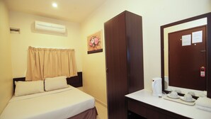 A hotel room with a bed, a wardrobe, a desk with a mirror, and a coffee maker. - Anggerik Lodging Hotel (George Town)