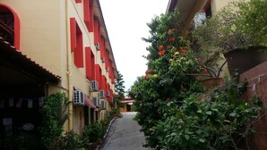 A narrow alleyway with buildings on either side, potted plants, and a 'Welcome' sign at the entrance. - Anggerik Lodging Hotel (George Town)