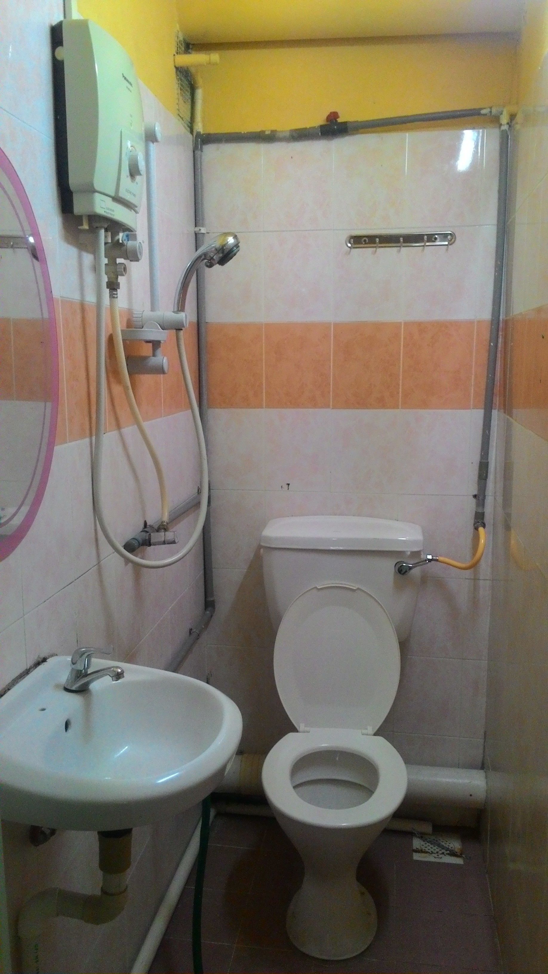 A small bathroom with a toilet, sink, and shower.