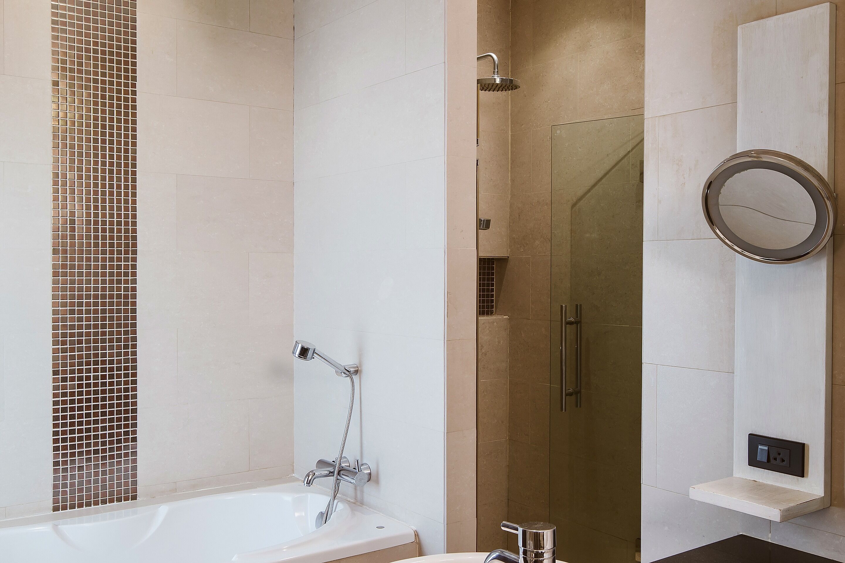 A modern bathroom with a bathtub, a shower, and a toilet.