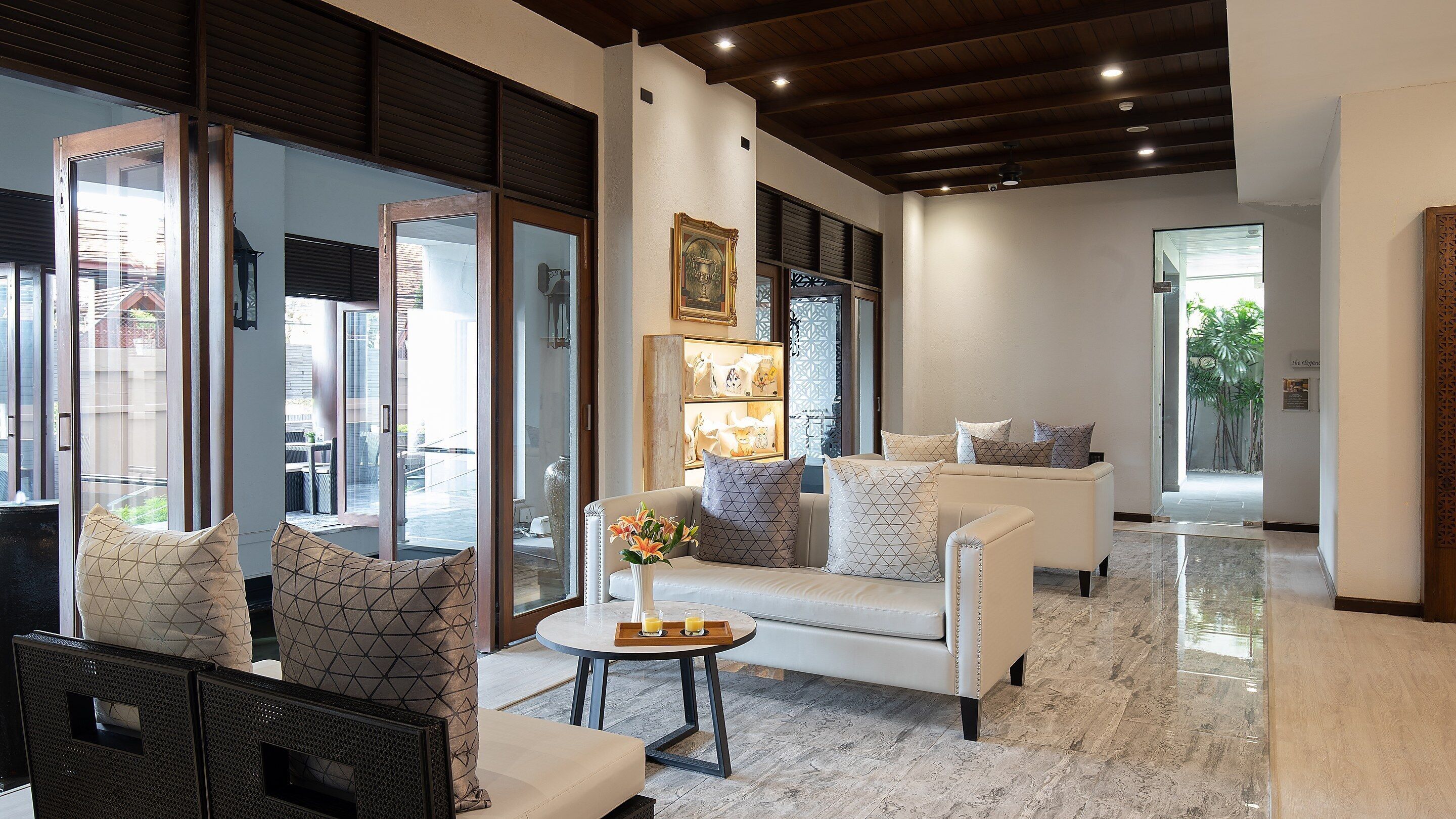 A modern living room with a sofa, armchairs, a coffee table, and a decorative vase.