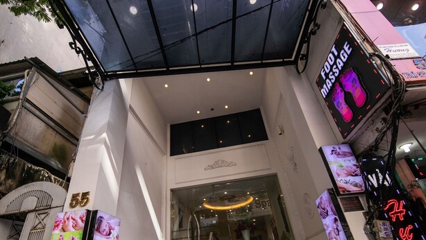 The entrance to Rosa Hotel & Spa with a visible foot massage sign and a digital display advertising foot massage services. - Rosa Hotel & Spa (Ho Chi Minh City)