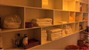 A hotel bathroom with multiple shelves holding towels and toiletries. - Rosa Hotel & Spa (Ho Chi Minh City)