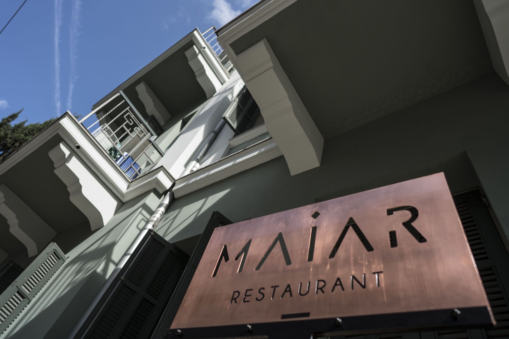 A building with a sign that reads 'MAiR RESTAURANT' on the front.
