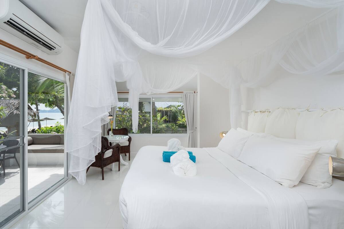 Ein Hotelzimmer mit einem großen Bett, einem Balkon mit Blick und einer Schiebetür.