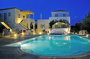 Una piscina al aire libre, sombrillas, sillones reclinables de piscina