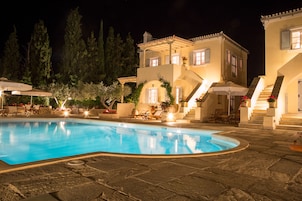 Una piscina al aire libre, sombrillas, sillones reclinables de piscina