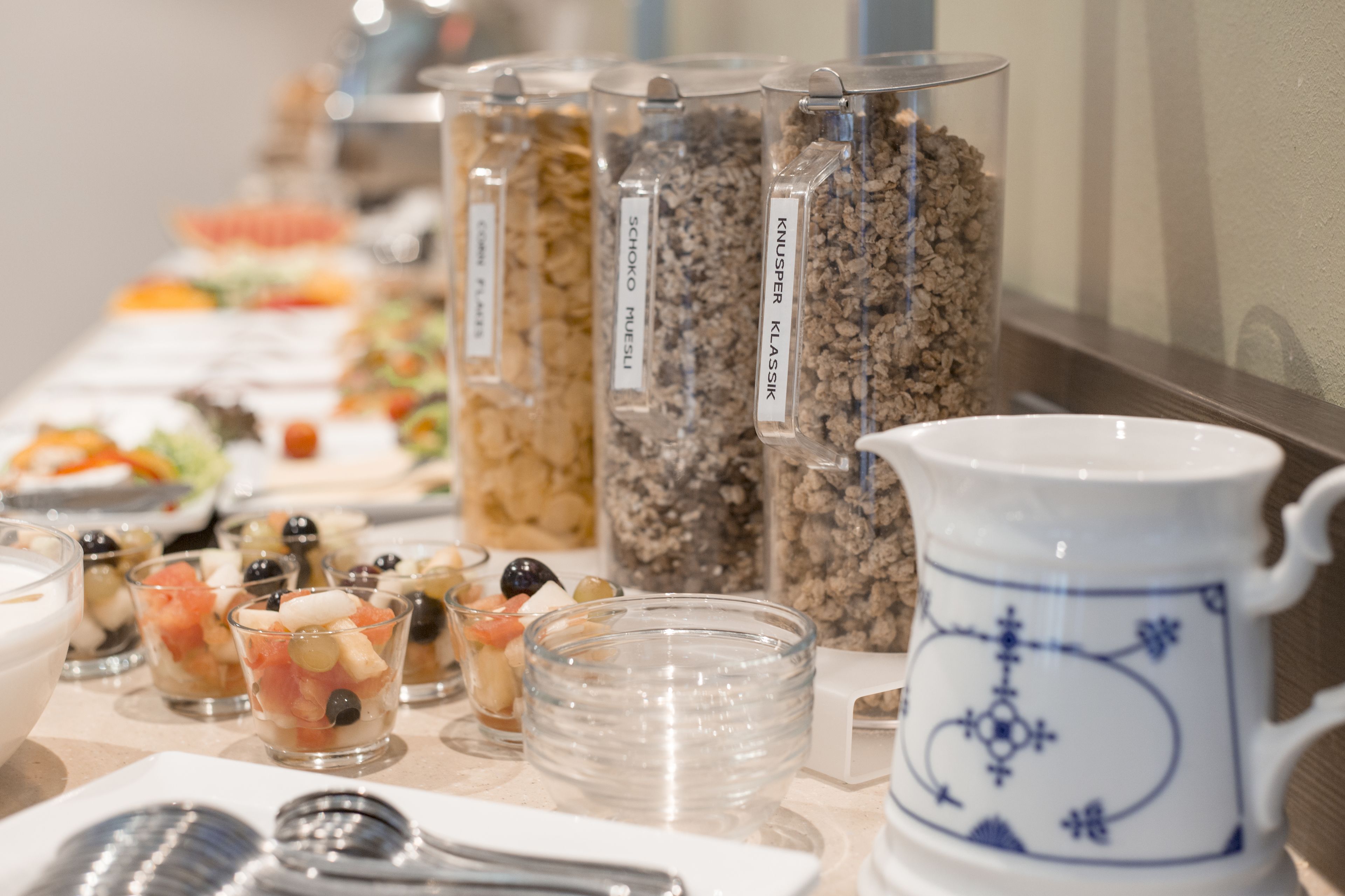 Ein Buffet mit verschiedenen Speisebehältern und einer dekorativen Karaffe.