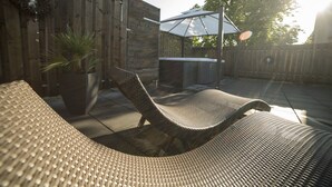 A patio with a wicker lounge chair, a potted plant, and a barbecue grill. - Hotel zur Krone (Gescher)