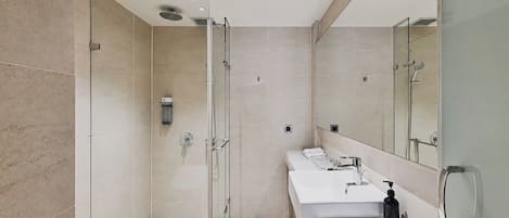 A modern bathroom with a glass-enclosed shower, a vanity with a mirror, and a marble countertop.