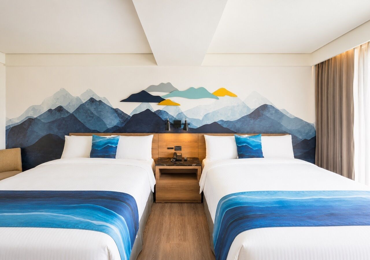 A hotel room with two beds, a nightstand, and a wall mural.