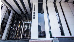 Un bâtiment moderne doté d’une façade en verre et d’éléments structurels blancs.