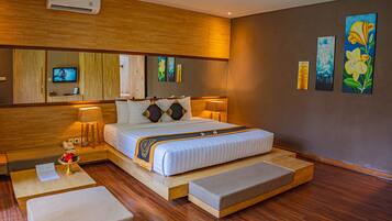 Ein modernes Hotelzimmer mit einem großen Bett, Nachttischlampen, Holzboden und Bildern an den Wänden.