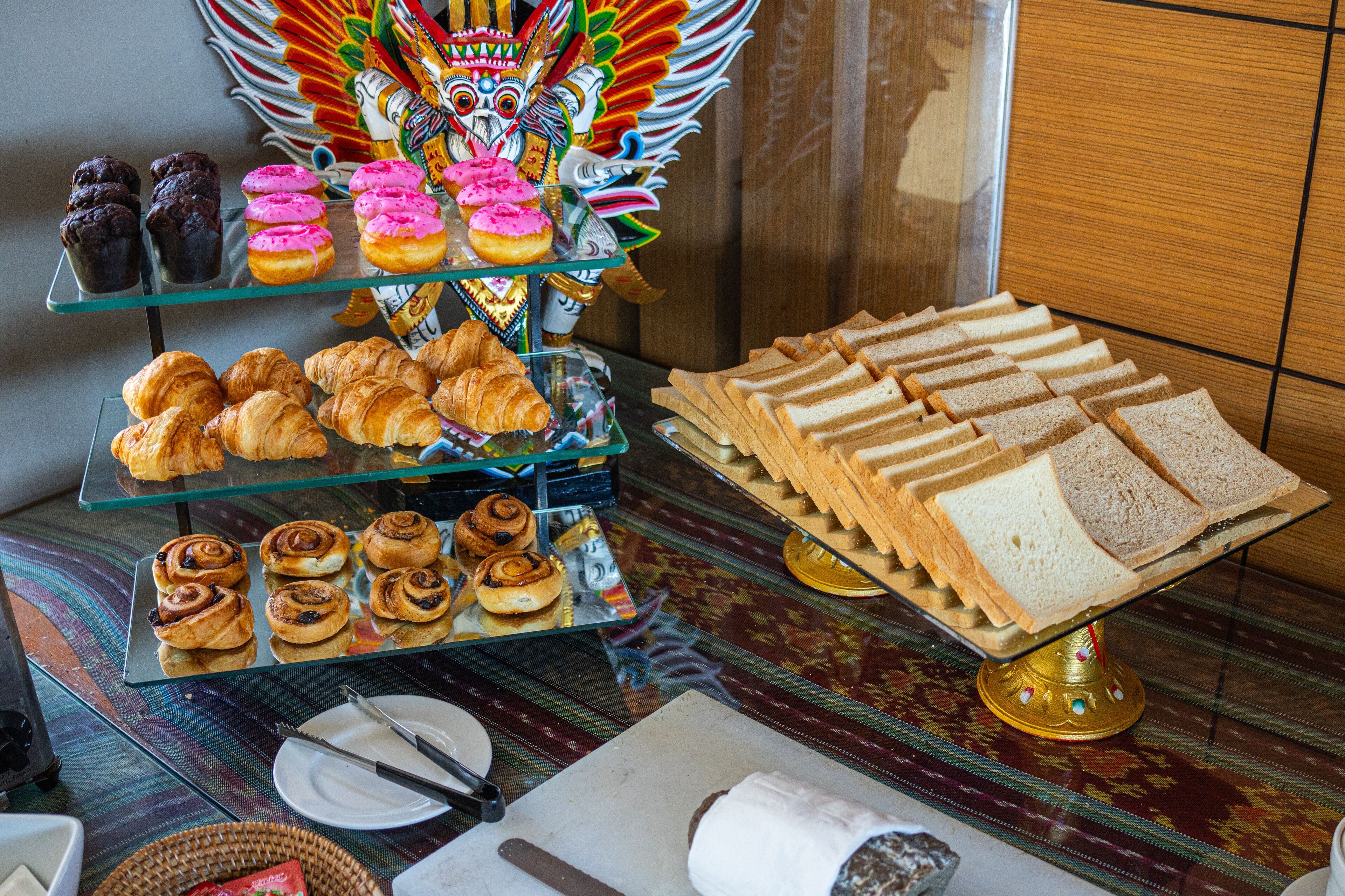 Un buffet proposant des pâtisseries, des sandwichs et un masque décoratif.