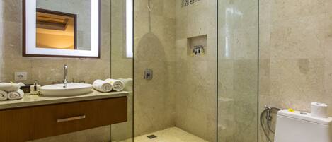 A modern bathroom with a glass-enclosed shower, a sink with a mirror, and a toilet.