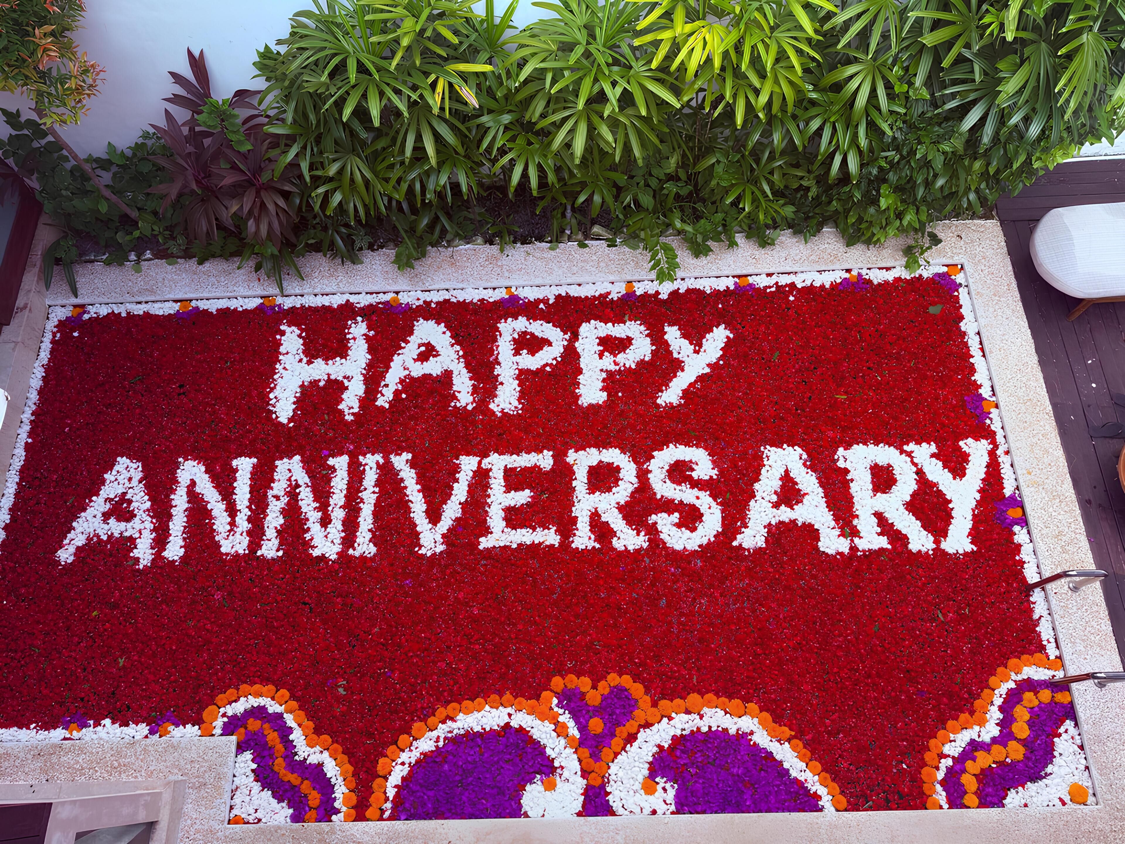 A red flower bed with "HAPPY ANNIVERSARY" written in white.