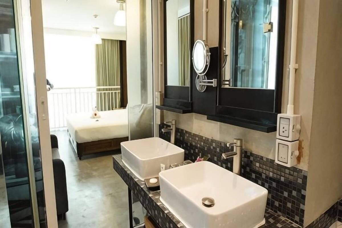 A bathroom with two sinks, a mirror, and a shower.