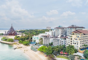 A coastal hotel with multiple buildings, a beach, and a temple. - Pattaya Modus Beachfront Resort (Pattaya)