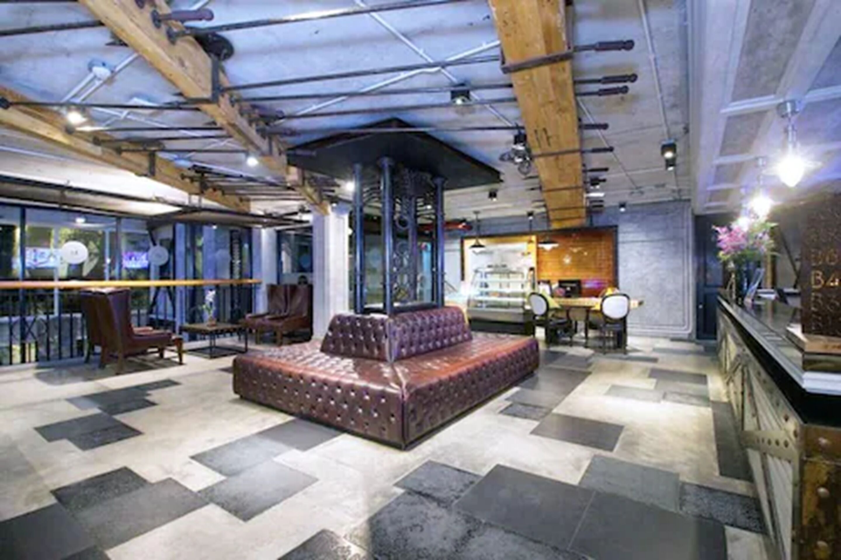 Ein modernes Interieur mit einer zentralen Sitzgruppe, einer Bar und einer Glastrennwand.