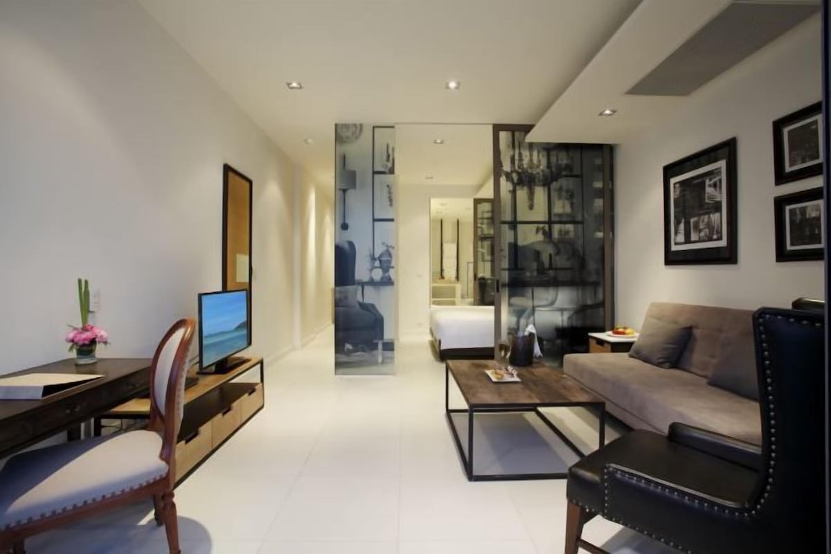 Una sala de estar moderna con un sofá, una mesa de centro, un televisor y un escritorio con una silla.