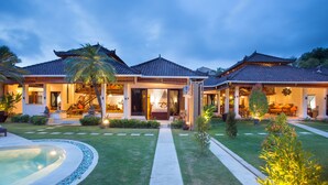 A traditional-style house with a swimming pool, well-maintained lawn, and a clear pathway leading to the entrance. - Dyana Villas (Seminyak)