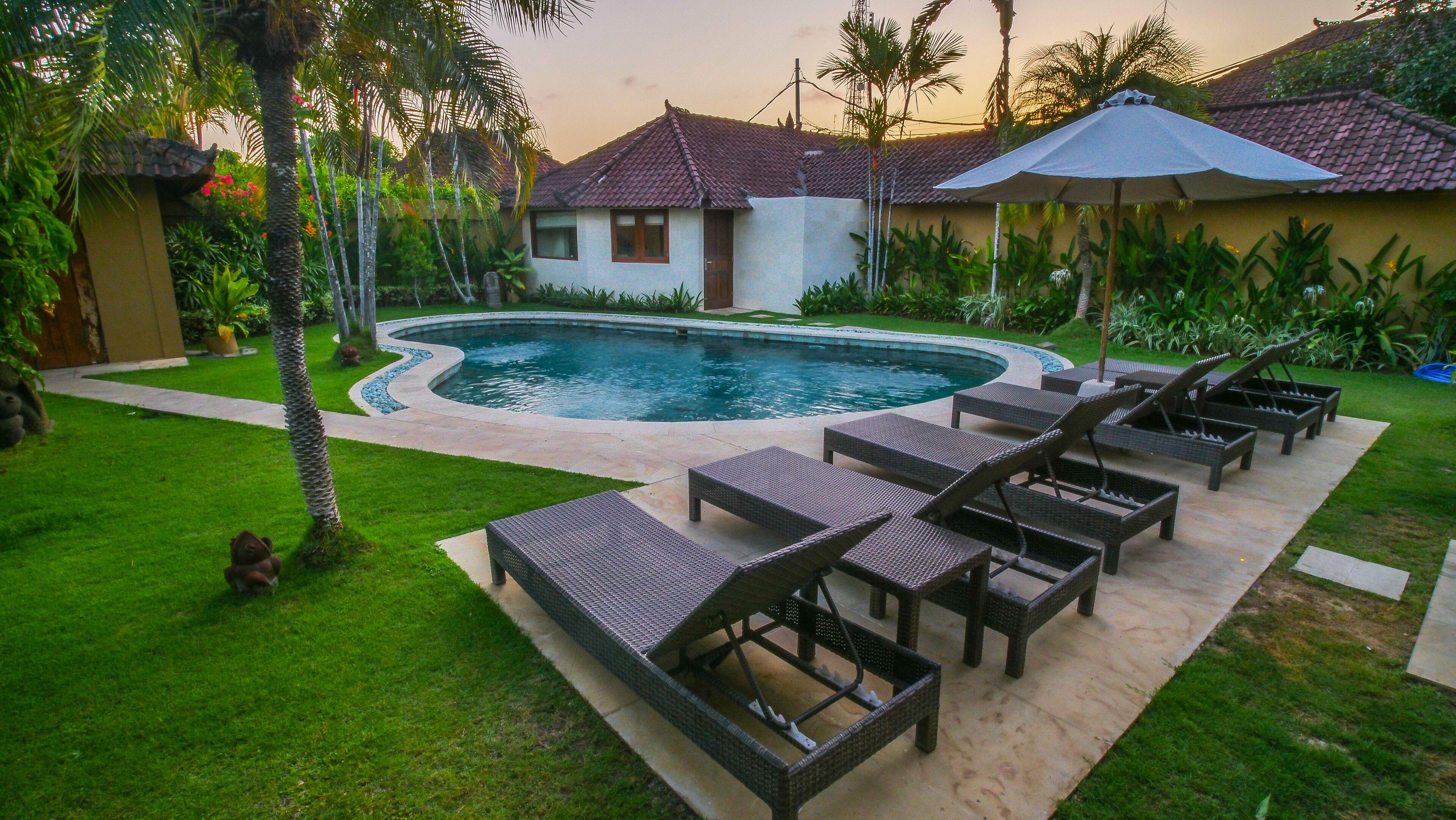 A swimming pool with lounge chairs and a patio area.