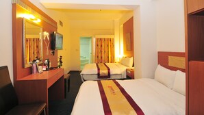 A hotel room with a bed, a desk, a mirror, and a television. - Li Qing Hotel (Kaohsiung)