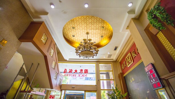 A hotel lobby with a large chandelier, a digital clock, and a sign with Chinese characters. - Li Qing Hotel (Kaohsiung)