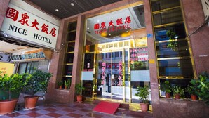 The exterior of the NICE HOTEL with clear signage, a checkered pavement, and potted plants. - Li Qing Hotel (Kaohsiung)