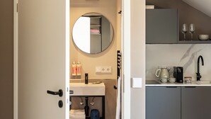 A modern kitchen with grey cabinets, a black faucet, and a coffee machine. - Numa Munich St Paul (Munich)