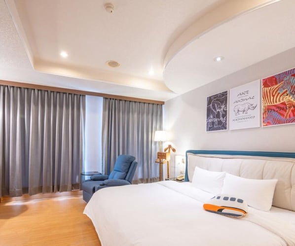 Una habitación de hotel con una cama grande, una silla, un escritorio y cortinas.