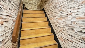 Un escalier avec des marches en bois et un mur de pierre de chaque côté.