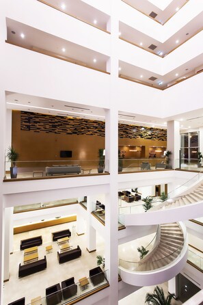 A multi-level hotel lobby with a central staircase, seating areas, and a reception desk. - Divan Gaziantep (Gaziantep)
