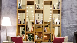 A living room with two sofas, a coffee table, and a bookshelf filled with books.