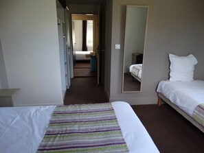 A hotel room with a large bed, a smaller bed, a mirror, and a wardrobe. - Hôtel Restaurant l'Echo du Lac & Spa (Gerardmer)