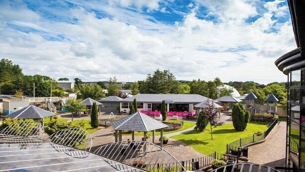 Un hotel con varias construcciones, zonas de estar al aire libre y un jardín bien cuidado.
